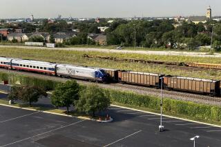 An Amtrak passenger train and a freight train head northbound towards downtown Chicago Wednesday, Sept. 14, 2022, in Chicago. Business and government officials are preparing for a potential nationwide rail strike at the end of this week while talks carry on between the largest U.S. freight railroads and their unions. (AP Photo/Charles Rex Arbogast)