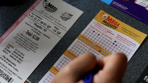 A customer fills out a Mega Millions lottery ticket at a convenience store Thursday, July 21, 2022, in Northbrook, Ill. Lottery officials have raised the Mega Millions grand prize to $660 million Thursday, July 21, 2022, giving players a shot at the nation's ninth largest jackpot. (AP Photo/Nam Y. Huh)