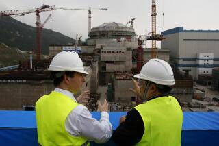 FILE - In this Oct. 17, 2013, file photo, then British Chancellor of the Exchequer George Osborne, left, chats with Taishan Nuclear Power Joint Venture Co. Ltd. General Manager Guo Liming as he inspects a nuclear reactor under construction at the nuclear power plant in Taishan, southeastern China's Guangdong province. The French joint operator of the Chinese nuclear plant near Hong Kong said Monday it is dealing with a “performance issue” but is currently operating within safety limits, following a report of a potential radioactive leak. (AP Photo/Bobby Yip, Pool, File)