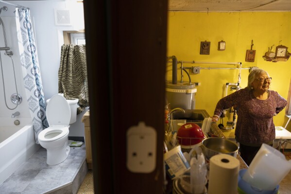 Mary Lou Beaver stands beside her family's kitchen sink, Thursday, Aug. 17, 2023, in Akiachak, Alaska. (AP Photo/Tom Brenner)