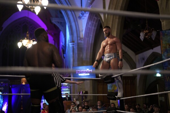 Tucker, exluchador de WWE NXT UK, se encuentra contra las cuerdas en el espectáculo Kingdom Wrestling en la iglesia de San Pedro en Shipley, el sábado 29 de marzo de 2025. (Foto AP/Jon Super)