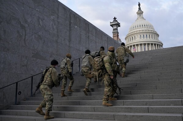 FILE - National Guard members take a staircase toward the U.S. Capitol building before a rehearsal for President-elect Joe Biden's Presidential Inauguration in Washington on Jan. 18, 2021. Experts in constitutional law and the military say the Insurrection Act gives presidents tremendous power with few restraints. Recent statements by former President Donald Trump raise questions about how he might use it if he wins another term. (AP Photo/Patrick Semansky, File)