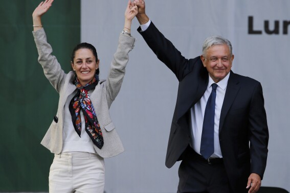 Mexico's President Andres Manuel Lopez Obrador, right, and Mayor Claudia Sheinbaum, greet supporters at a rally in Mexico City's main square, the Zocalo, July 1, 2019. Now the leading presidential candidate in the upcoming June 2, 2024 election, Sheinbaum said that she believes in science, technology and renewable energy but also has said that if she wins she would continue increasing power generation by state-owned companies, which often run power plants with oil and coal. (AP Photo/Fernando Llano, File)