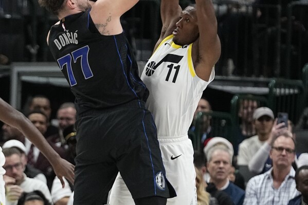 Dallas Mavericks guard Luka Doncic (77) shoots against Utah Jazz guard Kris Dunn (11) during the first half of an NBA basketball game in Dallas, Wednesday, Dec. 6, 2023. (APPhoto/LM Otero)