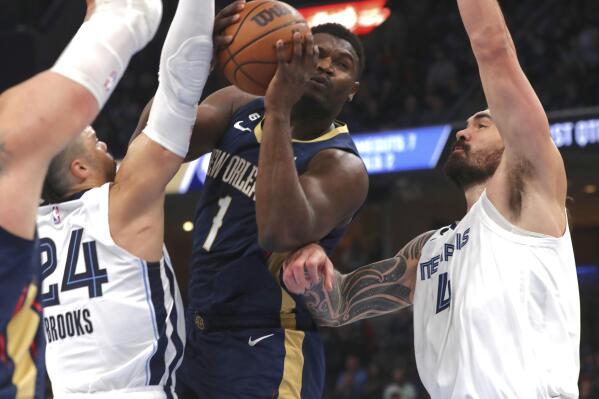 New Orleans Pelicans forward Zion Williamson (1) shoots while defended by Memphis Grizzlies guard Dillon Brooks (24) and center Steven Adams (4) during the first half of an NBA basketball game Saturday, Dec. 31, 2022, in Memphis, Tenn. (AP Photo/Nikki Boertman)