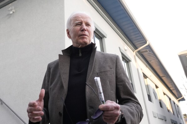 FILE - President Joe Biden speaks with reporters as he leaves St. Edmund Roman Catholic Church in Rehoboth Beach, Del., Saturday, Feb. 17, 2024, after attending a Mass. On Friday, Feb. 23, The Associated Press reported on stories circulating online incorrectly claiming Biden issued Executive Order 9066, which provides people who enter the U.S. illegally with a $5,000 Visa gift card. (AP Photo/Alex Brandon, File)