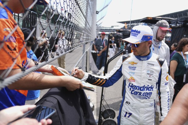 Kyle Larson signs autographs for fans during practice for the Indianapolis 500 auto race at Indianapolis Motor Speedway in Indianapolis, Wednesday, May 14, 2025. (AP Photo/Michael Conroy)