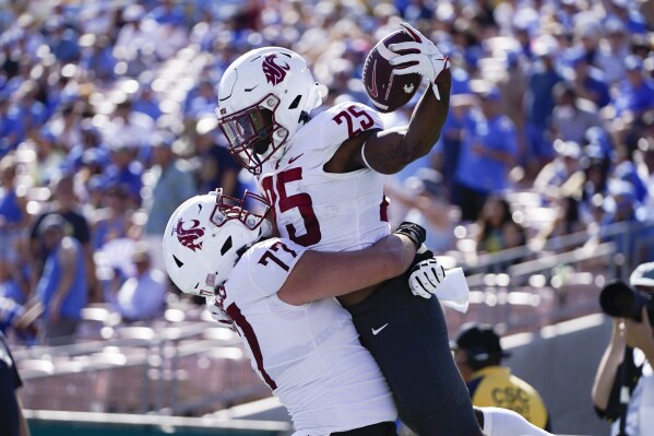 Washington State running back Nakia Watson, right, celebrates his touchdown with offensive lineman Konner Gomness during the second half of an NCAA college football game against UCLA, Saturday, Oct. 7, 2023, in Pasadena, Calif. (AP Photo/Ryan Sun)