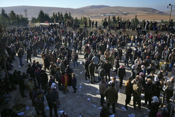 People stand outside the infamous Saydnaya military prison, just north of Damascus, Syria, Monday, Dec. 9, 2024. Crowds are gathering to enter the prison, known as the 