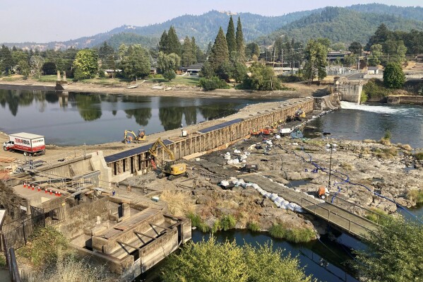 In this photo provided by James V. McCarthy, Oregon’s Winchester Dam, about five miles north of Roseburg, Ore., undergoes repairs Aug. 20, 2023. Oregon officials are seeking more than $27 million in damages over the dam repairs that they say killed more than half a million Pacific lamprey fish. The Oregon Department of Fish and Wildlife filed the claim in Douglas County Circuit Court on Friday, Oct. 6, 2023. (James V. McCarthy via AP)