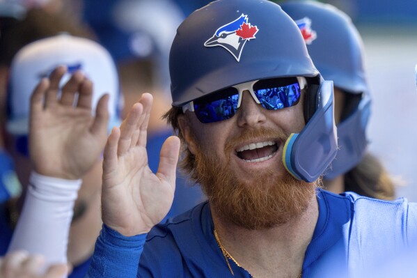 Toronto Blue Jays Justin Turner smiles as he is congratulated after scoring in first inning of a spring training baseball game against the Philadelphia Phillies in Dunedin, Fla., Saturday, Feb. 24, 2024. (Frank Gunn/The Canadian Press via AP)