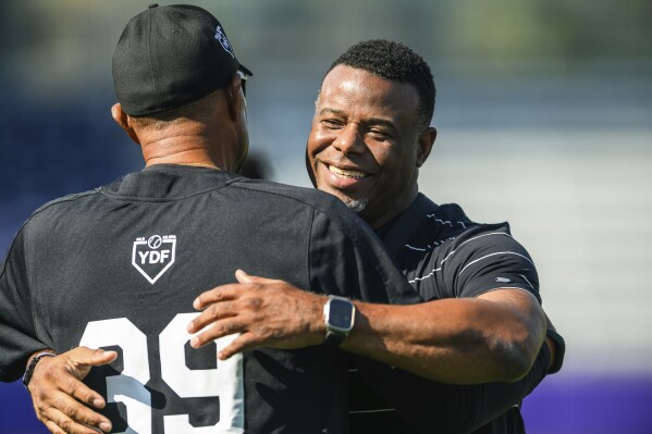 MLB Hall of Fame player Ken Griffey Jr. embraces a member of the coaching staff during a workout session the day before the HBCU Swingman Classic during the 2023 All Star Week, Thursday, July 6, 2023, in Seattle. (AP Photo/Caean Couto)