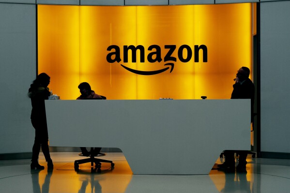 FILE - In this Feb. 14, 2019 file photo, people stand in the lobby for Amazon offices in New York. Amazon finally has its answer to ChatGPT. The tech giant said Tuesday, Nov. 28, 2023, it will launch Q 鈥� a generative-AI powered chatbot for businesses. (AP Photo/Mark Lennihan, File)