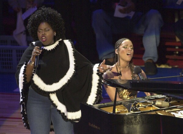 Alicia Keys, right, and Angie Stone, perform "America the Beautiful" during the NBA All-Star game in Philadelphia, Feb. 10, 2002. (AP Photo/Dan Loh, file)