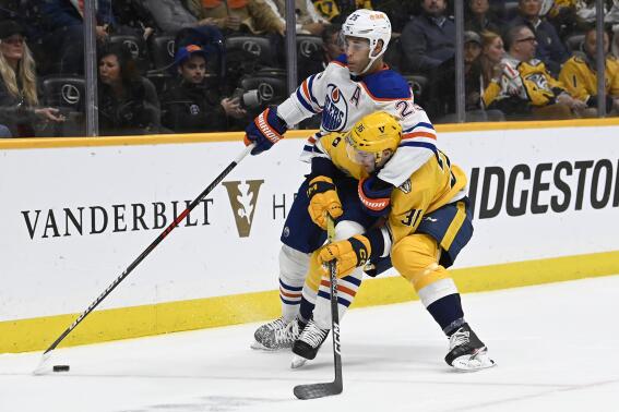 Edmonton Oilers defenseman Darnell Nurse (25) and Nashville Predators left wing Cole Smith (36) battle for the puck during the second period of an NHL hockey game Tuesday, Dec. 13, 2022, in Nashville, Tenn. (AP Photo/Mark Zaleski)