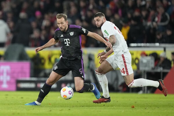 Bayern's Harry Kane, left, challenges for the ball with Cologne's Julian Chabot during the German Bundesliga soccer match between 1.FC Cologne and Bayern Munich in Cologne, Germany, Friday, Nov. 24, 2023. (AP Photo/Martin Meissner)