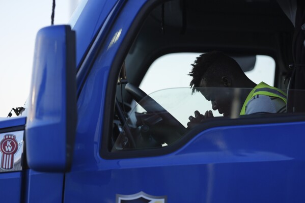 Haitian immigrant Kevenson Jean, a truck driver, prays before beginning a road trip, Tuesday, April 15, 2025, in Panhandle, Texas. (AP Photo/Eric Gay)
