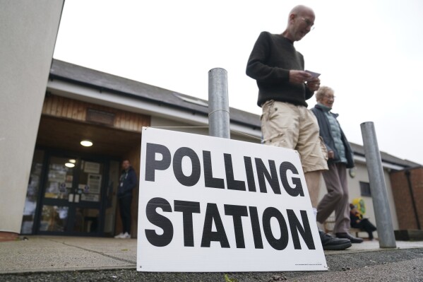 People exit the Shefford Town Memorial Association after casting their vote in the Mid Bedfordshire by-election, in Shefford, England, Thursday, Oct. 19, 2023. Voters are casting ballots Thursday in two special elections in England that could add more misery to the beleaguered governing Conservative Party. The Conservatives won both Tamworth in central England and Mid-Bedfordshire, north of London, by large margins during the last national election, in 2019. But both constituencies’ lawmakers resigned under a cloud. (Joe Giddens/PA via AP)