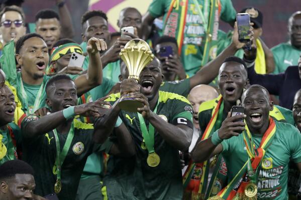 Senegal's players celebrate with trophy after winning the African Cup of Nations 2022 final soccer match between Senegal and Egypt at the Ahmadou Ahidjo stadium in Yaounde, Cameroon, Sunday, Feb. 6, 2022. (AP Photo/Sunday Alamba)