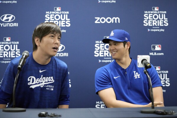 Shohei Ohtani of the Los Angeles Dodgers, right, and his interpreter, Ippei Mizuhara, attend a press conference before a baseball practice at Gocheok Sky Dome in Seoul, South Korea, Saturday, March 16, 2024. Ohtani's performer and close friend has been fired by the Dodgers following accusations of illegal gambling and theft from the Japanese baseball star.  (AP Photo/Lee ​​Jin-man)