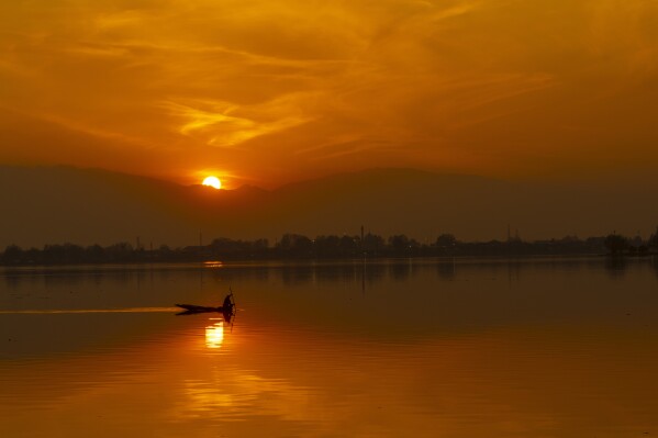 A fisher rows his Shikara, or traditional wooden boat, on his way home during sunset at the Dal Lake, in Srinagar, Indian controlled Kashmir, Feb. 7, 2025. (AP Photo/Dar Yasin, File)