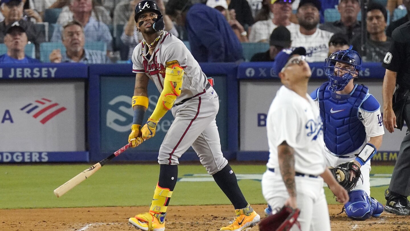 Los Angeles Dodgers' Mookie Betts, right, hits a three-run home run as  Atlanta Braves catcher Sean Murphy watches during the fifth inning of a  baseball game Thursday, Aug. 31, 2023, in Los