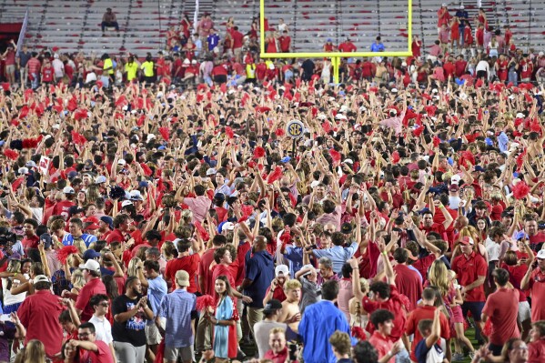 Mississippi fans celebrate on the field after an NCAA college football game against LSU in Oxford, Miss., Saturday, Sept. 30, 2023. (AP Photo/Thomas Graning)