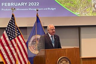 Democratic Minnesota Gov. Tim Walz answers questions from the media on the state's newly projected $9.3 billion budget surplus in St. Paul, Minn., on Monday, Feb. 28, 2022. The updated forecast was $1.5 billion more than an already-huge budget surplus projected back in November. (AP Photo/Mohamed Ibrahim)