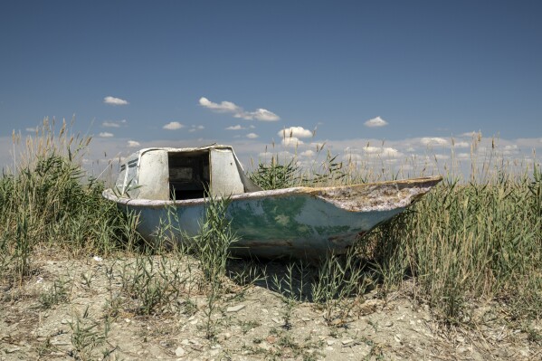 A worn-out boat sits near the dried-up Aral Sea, near Aralsk, Kazakhstan, Saturday, July 1, 2023. (AP Photo/Ebrahim Noroozi)