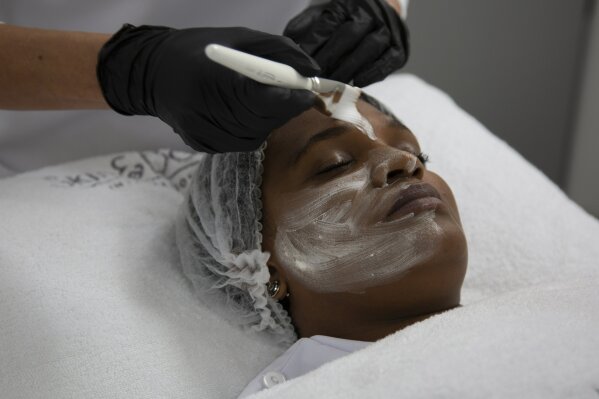 A skin lightening mask is applied to the face during a demonstration for the Associated Press Tuesday, July 7, 2020, at the Skin and Body International Centre in Lenasia, Johannesburg. For years, cosmetics giants Unilever and L’Oreal have marketed skin whitening creams to women across the globe with less-than-subtle ads promoting “fair skin” as more desirable than naturally darker shades. In the wake of mass protests against racial injustice in the U.S., these corporations are re-branding their skin lightening products in Africa, Asia and the Middle East, but for generations of women raised on their messaging, the new marketing is unlikely to reverse deeply rooted prejudices around “colorism”, the idea that fair skin is better than dark skin. (AP Photo/Denis Farrell)