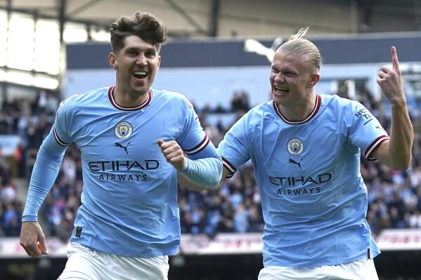 Manchester City's John Stones, left, celebrates with teammate Erling Haaland after scoring his side's opening goal during the English Premier League soccer match between Manchester City and Leicester City at Etihad Stadium in Manchester, England, Saturday, April 15, 2023. (Nick Potts/PA via AP)