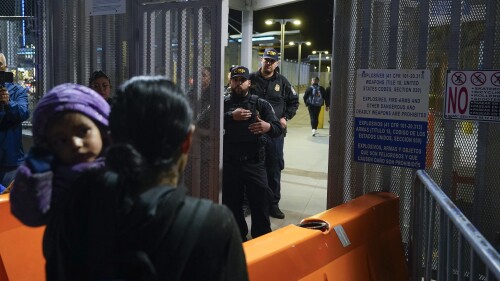 FILE - Paula, foreground, of Guatemala, holds her daughter as she asks U.S. Customs and Border Protection officials about new asylum rules at the San Ysidro Port of Entry on May 11, 2023, in Tijuana, Mexico. The Biden administration said Tuesday, June 13, 2023, that it will extend legal status for more than 300,000 people from El Salvador, Honduras, Nicaragua and Nepal for 18 months, disappointing some advocates and members of Congress who sought a more generous offer. (AP Photo/Gregory Bull, File)