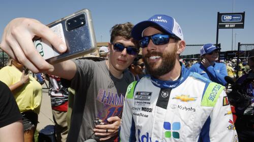 A fan, left, takes a photo with Ross Chastain, right, before a NASCAR Cup Series auto race at Kansas Speedway in Kansas City, Kan., Sunday, May 7, 2023. (AP Photo/Colin E. Braley)