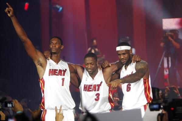 FILE - Chris Bosh, from left, Dwyane Wade and LeBron James acknowledge the cheers during a fan event at the American Airlines Arena in Miami, July 9, 2010. James ended weeks of speculation over his future by announcing his decision on an ESPN special that he has decided to leave the Cleveland Cavaliers and his home state of Ohio after seven years to join Wade and Bosh at the Miami Heat seeking his first championship. (AP Photo/J.Pat Carter)