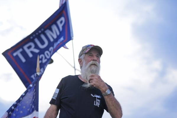 Supporter of former President Donald Trump, Mark Harvey, demonstrates near Trump's Mar-a-Lago estate, Thursday, May 30, 2024, in Palm Beach, Fla. (AP Photo/Wilfredo Lee)