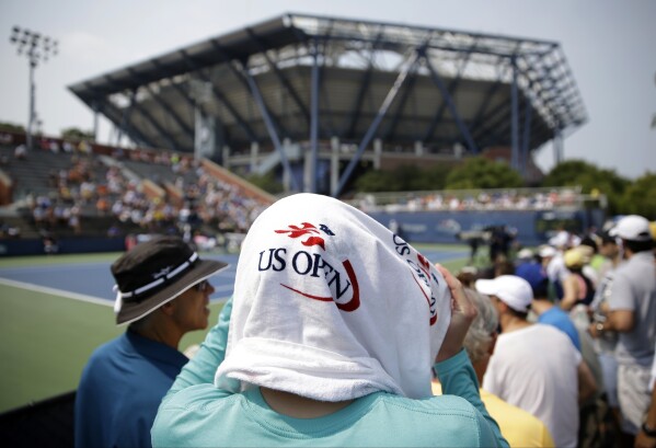 A spectator uses a towel to shade herself from the sun during the second round of the U.S. Open tennis tournament, Sept. 3, 2015, in New York. (AP Photo/Matt Rourke)