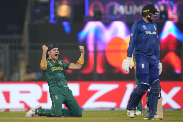 South Africa's Gerald Coetzee, left, celebrates the dismissal of England's Harry Brook during the ICC Men's Cricket World Cup match between South Africa and England in Mumbai, India, Saturday, Oct. 21, 2023. (AP Photo/ Rafiq Maqbool)