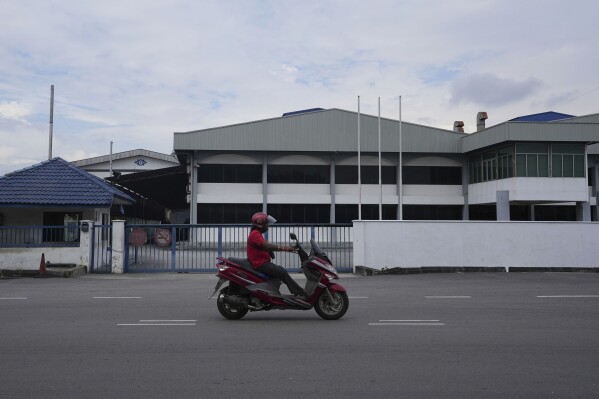 A motorcyclist rides past a Kawaguchi Manufacturing factory in Klang, Malaysia, Friday, Jan. 24, 2025. (AP Photo/Azneal Ishak)