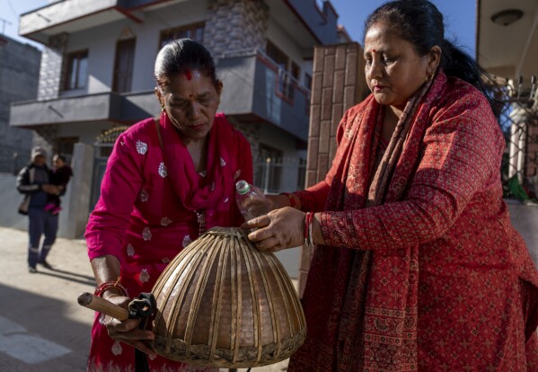 Machindra Thapa, 47, right, and Vishnu Maya Chettri, 52, prepare the Damaha, one of the instruments of the naumati baja, before a rehearsal in Kathmandu, Nepal, Tuesday, March 5, 2024. (AP Photo/Niranjan Shrestha)