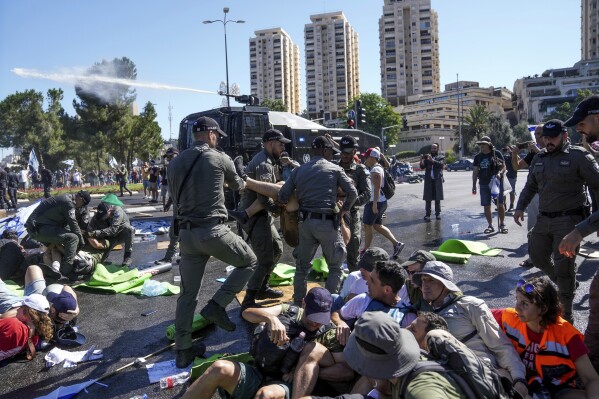 Israeli police disperse demonstrators blocking the road leading to the Knesset, Israel's parliament, during a protest against plans by Prime Minister Benjamin Netanyahu's government to overhaul the judicial system, in Jerusalem, Monday, July 24, 2023. The demonstration came hours before parliament is expected to vote on a key part of the plan. (AP Photo/Mahmoud Illean)