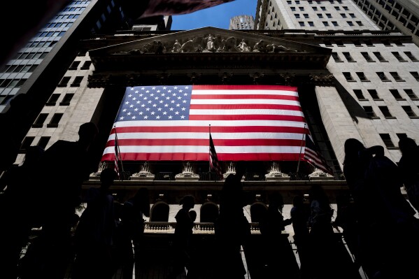 FILE - People walk past the New York Stock Exchange on Wednesday, June 29, 2022 in New York. (AP Photo/Julia Nikhinson)