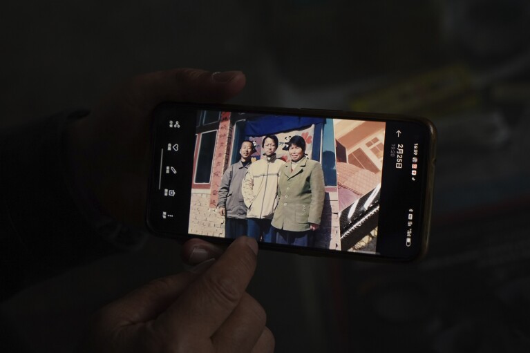 Chinese farmer Li Eryou shows a family photograph with himself, left, his son Li Yanlin, center, and his wife Liu Shuangfeng, right, on his cell phone at a village in Handan in northern China's Hebei province on Feb. 28, 2024. Li, whose son was on the missing Malaysia Airlines flight MH370, continues to search for answers ten years on. The baffling disappearance of flight MH370 still captivates people around the world. The Boeing 777 left Kuala Lumpur with 239 people on March 8, 2014, but dropped off radar screens shortly after and never made it to Beijing, its destination. Investigators say someone deliberately shut down the plane's communications system and took the plane off course. (AP Photo/Emily Wang Fujiyama)