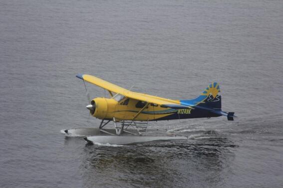 This Thursday, Aug. 5, 2021, photo provided by Lee LaFollette shows a de Havilland Beaver aircraft departing the Port of Ketchikan, Alaska. Foggy, reduced-visibility conditions have delayed efforts to recover the wreckage of a sightseeing plane that crashed in southeast Alaska, killing six people. Clint Johnson, chief of the National Transportation Safety Board’s Alaska region, says the agency had hoped to recover the wreckage Sunday. But he says those efforts were called off due to poor conditions. He says the crew planned to try again on Monday, Aug. 9, 2021. (Lee LaFollette via AP)