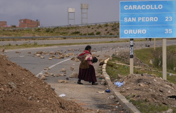 Una mujer aymara camina por el lateral de una carretera bloqueada por seguidores del expresidente Evo Morales, que protestan a raíz de la crisis judicial por la renovación de los magistrados, en Caracollo, Bolivia, el viernes 2 de febrero de 2024. (AP Foto/Juan Karita)