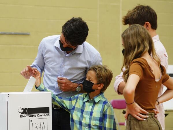 Liberal leader Justin Trudeau casts his ballot in the 44th general federal election as he's joined by his children, Xavier, Ella-Grace and Hadrien in Montreal on Monday, Sept. 20, 2021. (Sean Kilpatrick/The Canadian Press via AP)