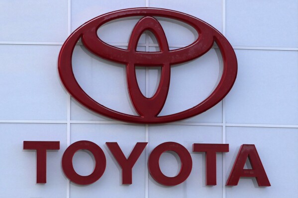FILE - The Toyota logo is shown on a dealership in Manchester, N.H., in this Thursday, Aug. 15, 2019, file photo. Toyota will invest an additional $8 billion in the hybrid and electric vehicle battery factory it's constructing in central North Carolina, more than doubling its prior investments and expected number of new jobs, the company announced Tuesday, Oct. 31, 2023. (AP Photo/Charles Krupa, File)