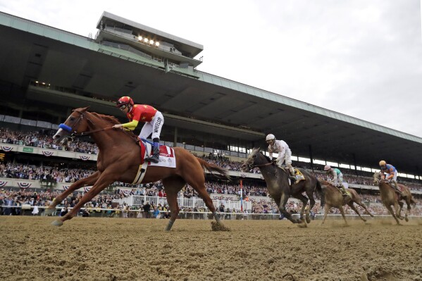 FILE - Justify (1), with jockey Mike Smith up, crosses the finish line to win the 150th running of the Belmont Stakes horse race, Saturday, June 9, 2018, in Elmont, N.Y. Triple Crown winner Justify, 2017 Horse of the Year Gun Runner and jockey Joel Rosario have been elected to the National Museum of Racing and Hall of Fame in their first year of eligibility. (AP Photo/Julio Cortez, File)