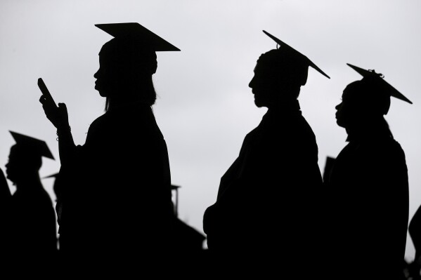 FILE - New graduates line up before the start of a community college commencement in East Rutherford, N.J., May 17, 2018. This summer, millions of Americans with student loans will be able to apply for a new repayment plan that offers some of the most lenient terms ever. Interest won鈥檛 pile up as long as borrowers make regular payments. Millions of people will have payments of $0. And starting in 2024, undergraduate loan payments will be reduced by half. (APPhoto/Seth Wenig, File)