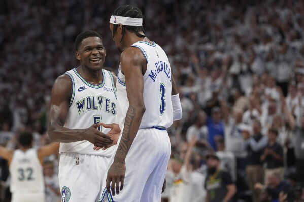 Minnesota Timberwolves forward Jaden McDaniels (3) celebrates with guard Anthony Edwards (5) after making a 3-point basket during the second half of Game 6 of an NBA basketball second-round playoff series against the Denver Nuggets, Thursday, May 16, 2024, in Minneapolis. (AP Photo/Abbie Parr)