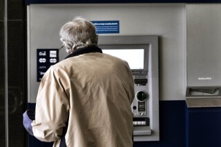 File - A customer makes a transaction at an automatic teller machine in Los Angeles on March 27, 2023. The cost to overdraw a bank account could drop to as little as $3 under a proposal announced by the White House, the latest move by the Biden administration to combat fees it says pose an unnecessary burden on American consumers, particularly those living paycheck to paycheck. (AP Photo/Richard Vogel, File)